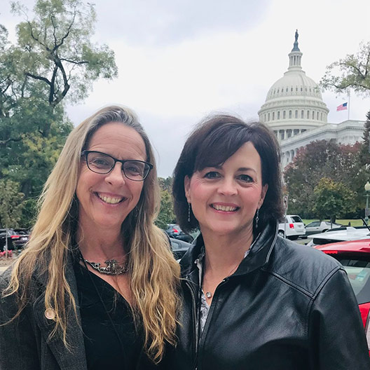 Photo of Jennifer Platt and Beth Carrison in front of capitol building